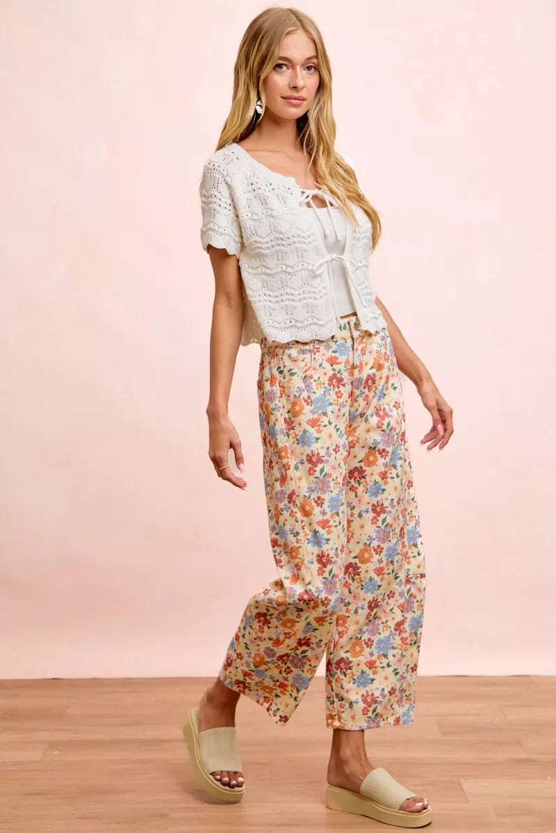 Woman wearing cream floral printed barrel-leg pants by BiBi with cream platform sandals.