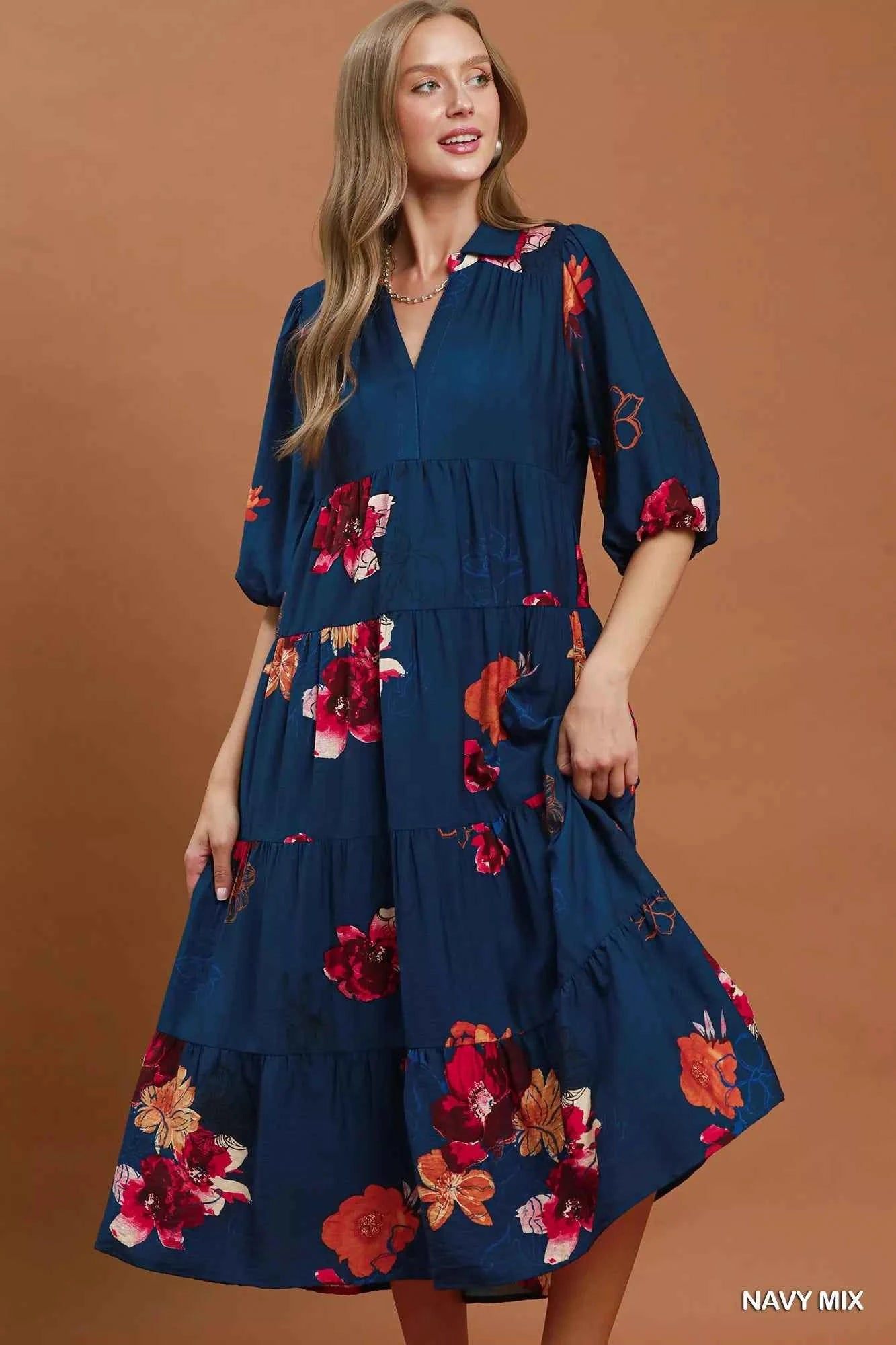 Woman wearing an Umgee navy floral tiered midi dress with puff sleeves, pockets, and a flowy feminine silhouette.
